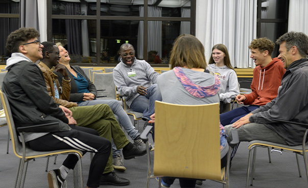 Eine Gruppe von Teilnehmenden bei einer ENSA-Konferenz sitzt im Stuhlkreis und ein großer Teil lacht