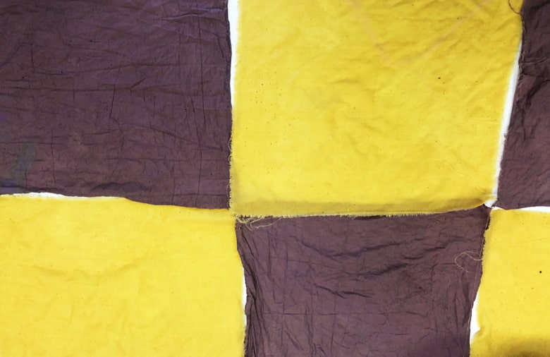 Auf dem Bild sind sechs Quadrate Stoffe abgebildet, die in zwei sehr kontrastierenden Tönen gefärbt sind (gelb und braun).