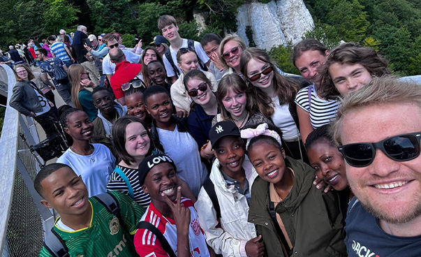 Die Schüler*innen des Hamburger Helene-Lange-Gymnasiums und der Kiluvya Secondary School in Dar es Salaam machen bei einem Tagesausflug ein Selfie mit einer begleitenden Lehrkraft.