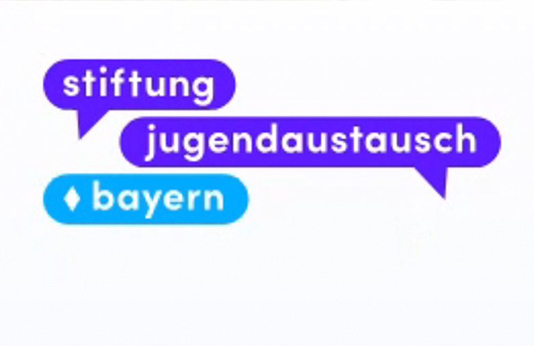Auf dem Bild ist das Logo der Stiftung Jugendaustausch Bayern zu sehen. In zwei dunkelblauen, schmalen Sprechblasen steht jeweils das Wort Stiftung und darunter jugendaustausch. In einer dritten hellblauen Blase steht das Wort Bayern.